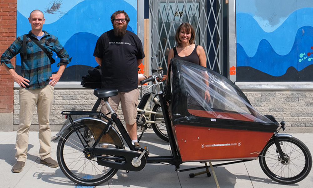 (left to right) Andrew Hunniford, London Bicycle Café's General Manager; Jonny Courey, Ark Aid Mission's Outreach Co-ordinator; and Dr. Lisa Sakida, Western neuroscientist and Scientific Co-Director, Western's BrainsCAN outside of The Ark on July 8th.