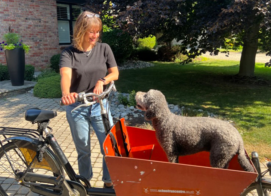 Lisa Saksida with her dog, Reggie, in the cargo bike she donated to Ark Aid Mission