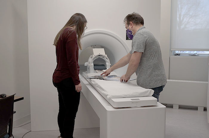 A technologist helping someone into an MRI machine